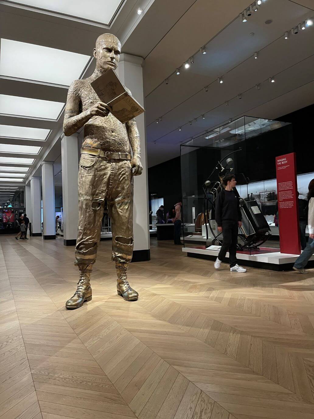la statua di una persona con in mano un libro al natural history museum 