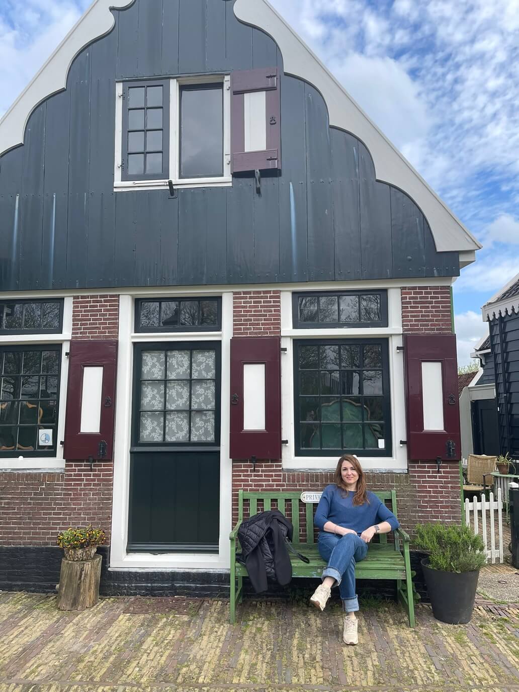chiara di viaggi e ritratti seduta di fronte a una casa di zaanse schans