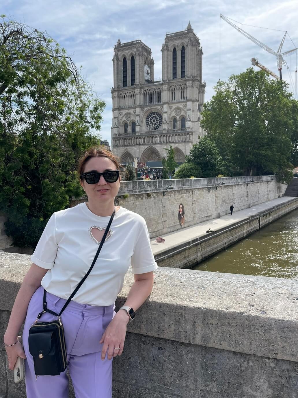 chiara di viaggi e ritratti con alle spalle la cattedrale di notre dame