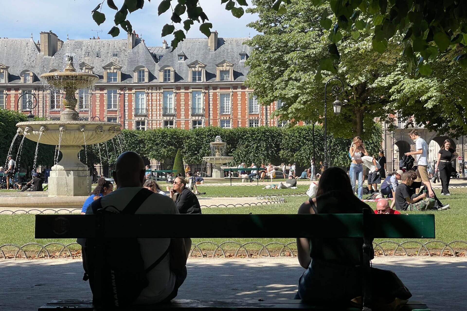 due persone sedute su una panchina a place des vosges